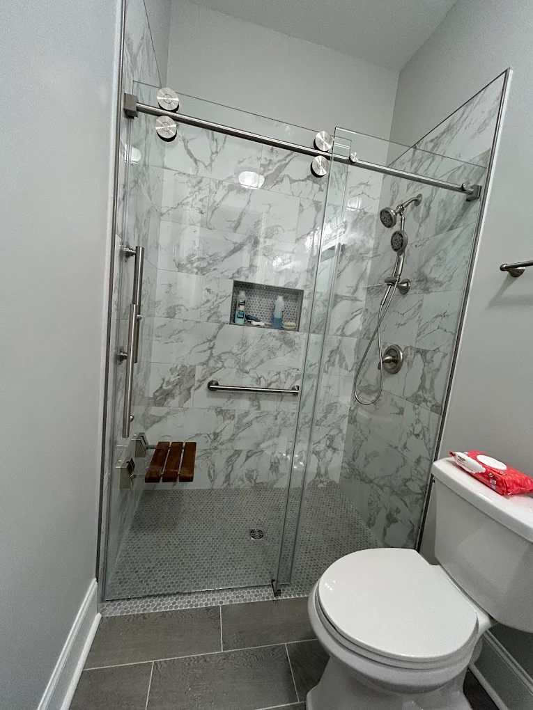 Remodeled bathroom with frameless glass and marble tile shower