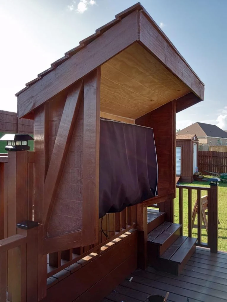 Custom-built backyard playhouse with covered roof